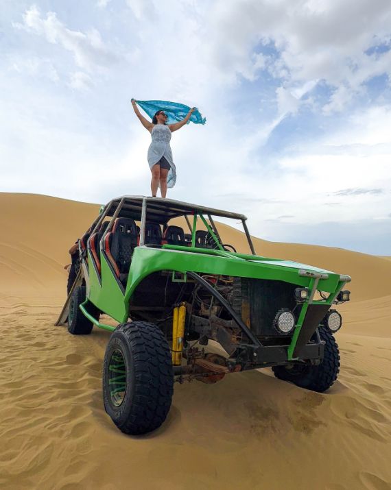 Turista sobre un tubular en las dunas de Huacachina