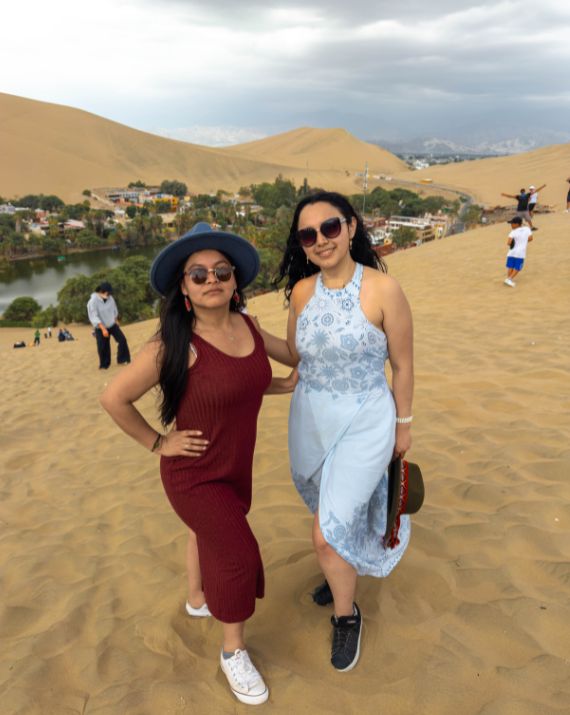 Dos viajeras caminando por las dunas del oasis de Huacachina
