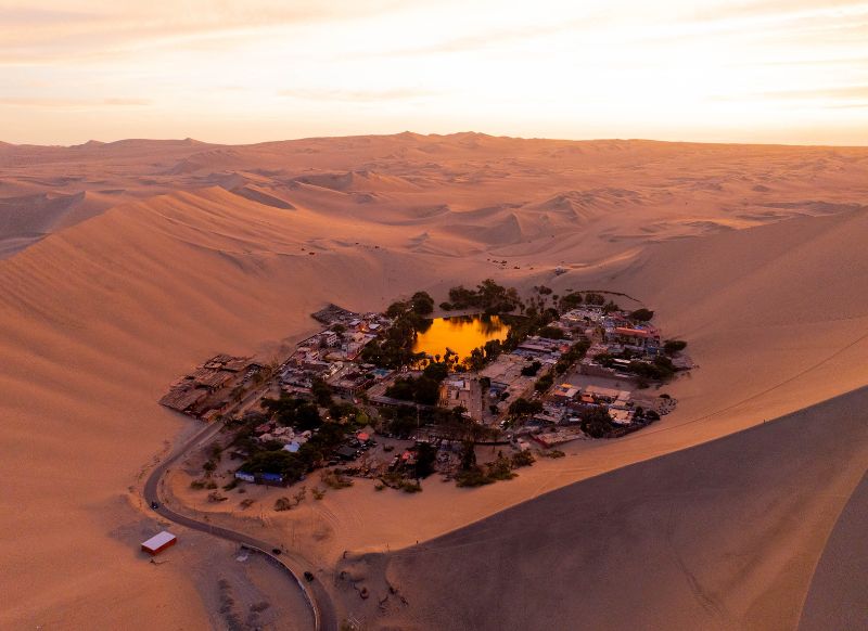 Vista aérea del oasis de Huacachina al atardecer durante el tour Get in Peru