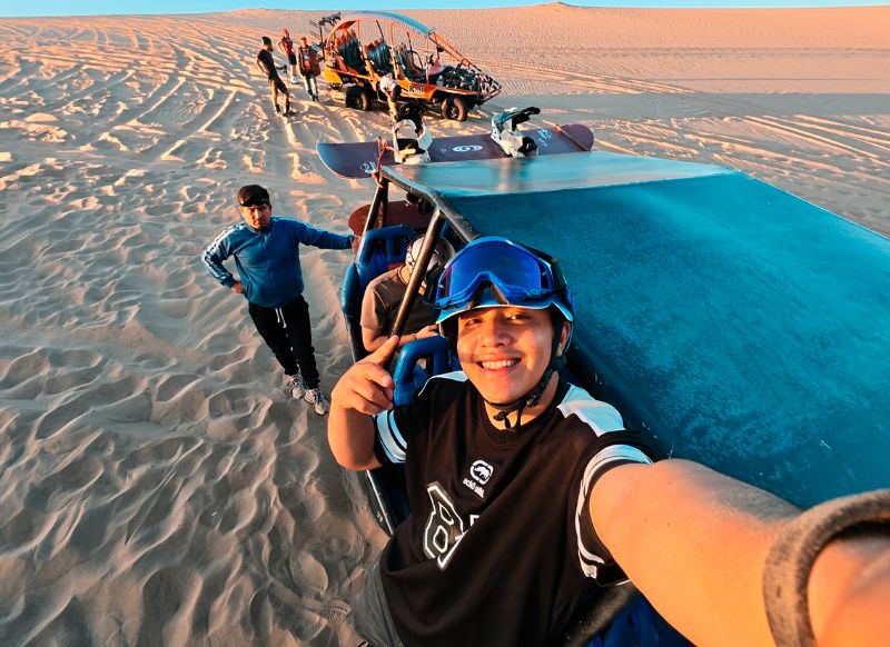 Turista junto a buggy en las dunas durante sandboarding full day Get in Peru
